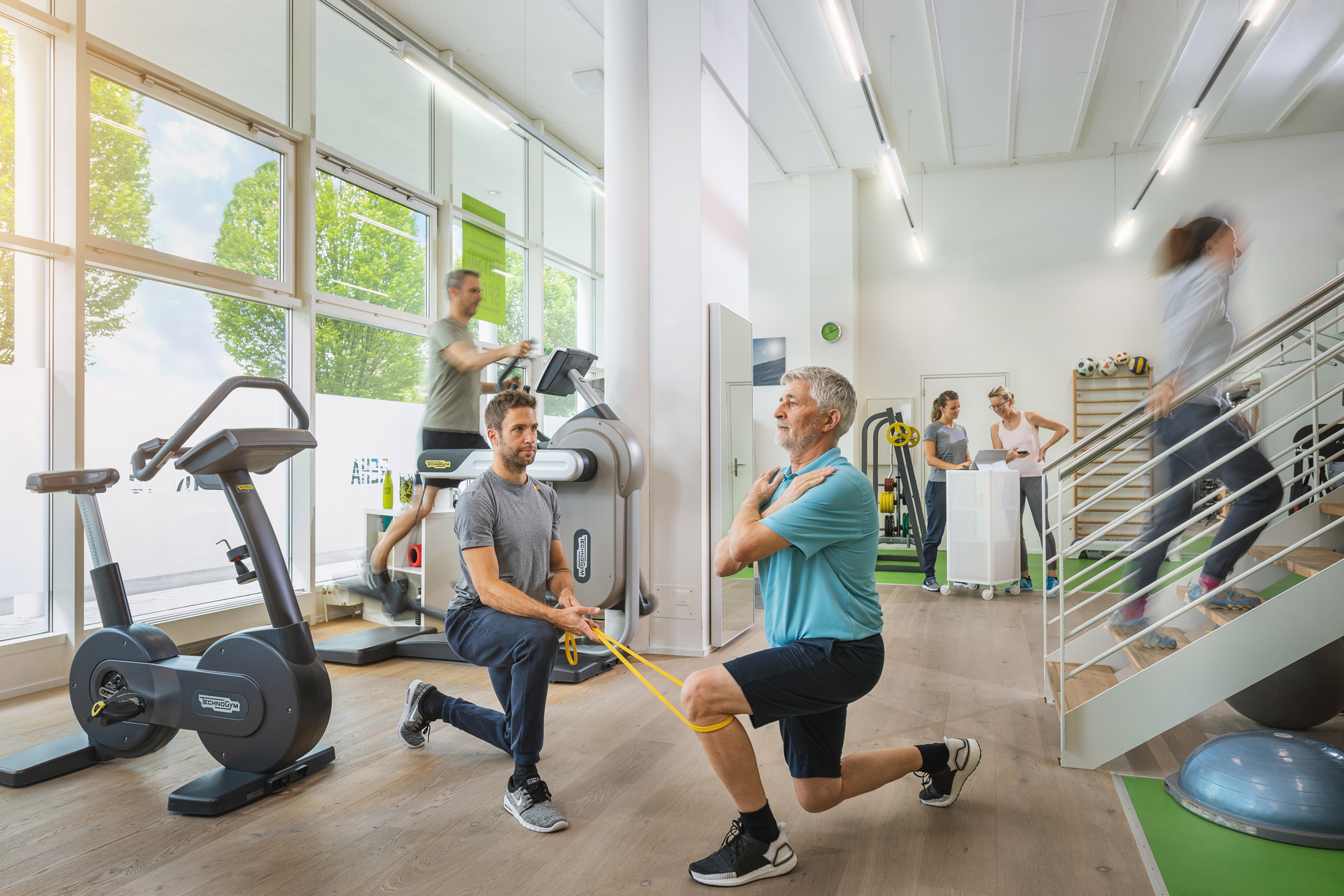 Ein Mann macht Übungen mit einem Physiotherapeuten in einer Praxis für Physiotherapie, damit er sein körperliches Wohlbefinden und seine Gesundheit verbessern kann.